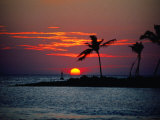 Soleil couchant derrière une île tropicale, Maldives Photographie par Michael Aw