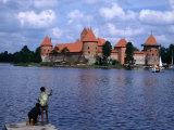 Boy Fishing from Lakeside Pier with Trakai Island Castle Behind, Trakai, Lithuania, Photographic Print by Jane Sweeney