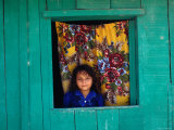 Little Girl in the Window of Her Brightly Painted House, Ciudad Melchor de Mencos, Guatemala Photographic Print by Jeffrey Becom