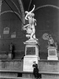 Man Sitting Beneath Statue of Giambologna's "Rape of the Sabine" in Loggia Dei Lanzi Photographic Print by Carl Mydans