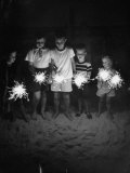Children Holding Sparklers on a Beach Photographie par Lisa Larsen