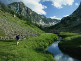 Hiker along a Stream in a Beartooth Mountains Valley Photographic Print by Kate Thompson