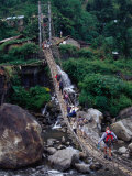 People Crossing Sagging Suspension Bridge Over Khudi Khola on Annapurna Circuit, Nepal Photographic Print by Tony Wheeler