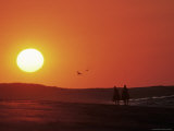 Couple Horseback Riding Into Sunset Photographic Print by Doug Page