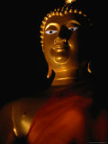 Illuminated Statue of Orange-Robed Buddha, Thailand Photographic Print by Tom Cockrem