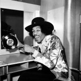 American Musician Jimi Hendrix in Dressing Room Holding a Copy of Single, Earing a Black Hat Fotografie-Druck