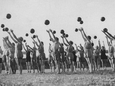 Women's Gym Class with Rows of Women Throwing Balls Into Air in Unison Photographic Print