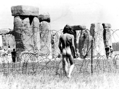 A Naked Hippy Watches Stonehenge from Behind Barb Wire on Summer Solstice