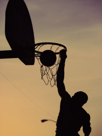 Silhouette of a Man Slam Dunking a Basketball Impressão fotográfica