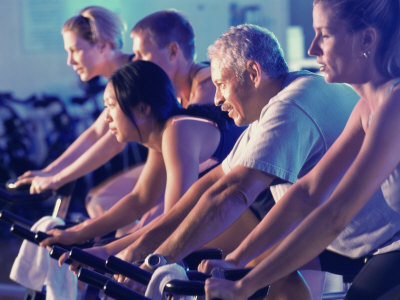 Group of People on Exercise Bikes in a Health Club Photographic Print