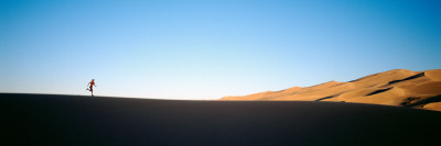 Low Angle View of a Woman Running in the Desert, Great Sand Dunes National Monument, Colorado, USA Photographic Print by  Panoramic Images