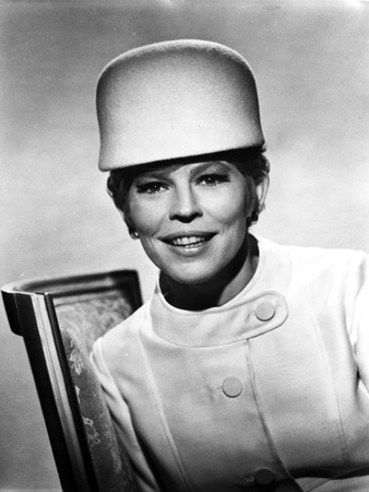 Ann Jackson sitting on a Chair wearing a White Coat in Classic Portrait Photo by  Movie Star News