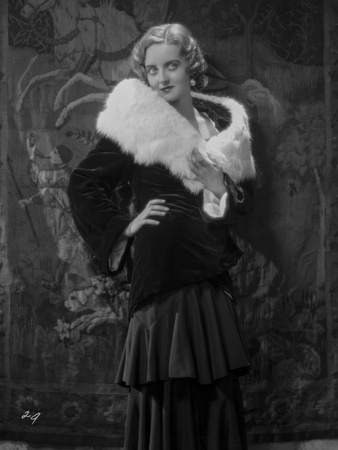 Bette Davis Posed Hand on the Waist in White Fur Boa in Black Long Sleeve Dress and Ruffled Skirt Photo by Jack Freulich