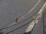 A Hunzukut Woman Crosses a Footbridge over the Hunza River Photographie par Jonathan Blair