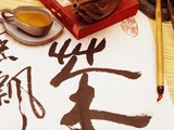 Caligrafía china en un pergamino junto a un juego de té Lámina fotográfica