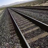 Railroad tracks running through desert setting Photographic Print