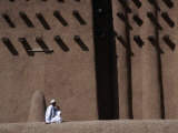 Man Sitting at Base of Mud-Brick Wall of the Grand Mosque, Djenne, Mopti, Mali Photographic Print by Jane Sweeney
