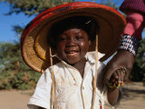 Young Smiling Boy Wearing a Typical Mali Hat and Holding His Mother's Hand, Djenne, Mopti, Mali Lámina fotográfica por Jane Sweeney