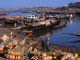 Fully Laden Pinasses Docked at the Jetty with More Cargo on the Shores of the Niger River, Mali Photographie par Patrick Syder