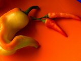 Chilli Peppers in Varying Shades on an Orange Plate, Australia Photographic Print by John Hay