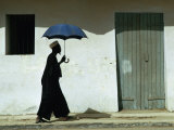 Man Walking with Umbrella, St. Louis, Senegal Fotografisk tryk af Eric Wheater Man Walking with Umbrella, St. Louis, Senegal Fotografisk tryk af Eric Wheater