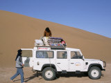 Loading Equipment on a 4X4 Vehicle after Desert Trek, Chigaga Dunes, Draa Valley, Morocco Photographic Print by Jenny Pate