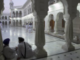 Two Sikhs Priests at Dawn Sitting Under Arcades, Golden Temple, Amritsar, Punjab State, India Fotografie-Druck von Eitan Simanor