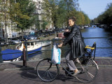 A Dutch Woman with Her Baby Cycling Along Kaizersgracht Canal, Amsterdam, the Netherlands (Holland) Photographie par Richard Nebesky