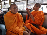 A Buddhist Monk Uses His Camcorder on a Bus in Vientiane, Laos, Indochina, Southeast Asia Photographic Print by Andrew Mcconnell