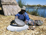 Uros (Urus) Woman Grinding Corn, Islas Flotantas, Reed Islands, Lake Titicaca, Peru, South America Photographic Print by Tony Waltham