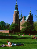 People Relaxing on Lawn with Rosenborg Slot Castle in Background, Copenhagen, Denmark Photographic Print by John Elk III