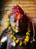 Deity with Garlands and Bindi Powder, Bhaktapur, Bagmati, Nepal Photographic Print by Anthony Plummer