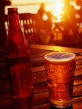 Bottle and Glass of Beer by Lake Vattern at Sunset, Motala, Ostergotland, Sweden Photographic Print by Anders Blomqvist