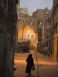 Woman Walking in Old Town, Dusk, San'a, Yemen Photographie par Holger Leue