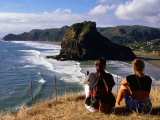 Couple on Bluff Overlooking Black Sand Beach, Piha, New Zealand Photographie par Oliver Strewe