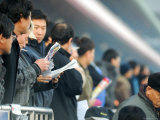 People Studying Form Guide at Seoul Racecourse, Seoul, South Korea Fotografisk tryk af Anthony Plummer