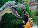 Woman Holding a Girl Up to a Dinosaur Model, Drumheller Valley, Alberta, Canada Photographic Print by Philip & Karen Smith