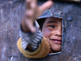 Boy Reaching through Hole in Gate, Alchi, Jammu and Kashmir, India Photographie par Daniel Boag