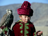 Young Boy Holding a Falcon, Golden Eagle Festival, Mongolia Photographie par Amos Nachoum