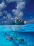 Female Divers Submerged Below Catamaran Photographic Print by Amos Nachoum