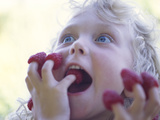 Girl Eating Raspberries, Bellingham, Washington, USA Photographic Print by Steve Satushek