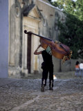 Musician Carrying Double Bass Along Cobbled Street to Plaza Mayor, Trinidad, Cuba Lámina fotográfica por Lee Frost Musician Carrying Double Bass Along Cobbled Street to Plaza Mayor, Trinidad, Cuba Lámina fotográfica por Lee Frost