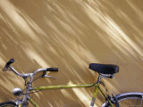 Bicycle Leaning against a Shadowed Yellow Wall, Parma, Italy Photographic Print by Gina Martin