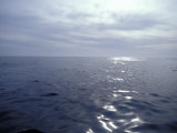 Calm Ocean with Small Ripples Reflects a Sunbeam Off the Surface, Australia Photographie par Jason Edwards