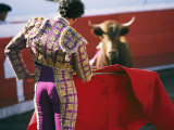 Bullfighter Holds his Red Cape Before a Bull Photographic Print by Pablo Corral Vega