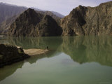 Man and Reflections of Mountains in the Quiet Yellow River, Qinghai, China Photographie par David Evans