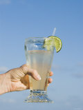 Lemonade, Lime and Straw Held in Womens Hand with Blue Sky Background, Ambergris Caye, Belize Fotografisk tryk af James Forte Lemonade, Lime and Straw Held in Womens Hand with Blue Sky Background, Ambergris Caye, Belize Fotografisk tryk af James Forte