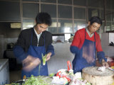 Restaurant Cooks Chop Food as They Prepare Meals, Qinghai, China Photographie par David Evans