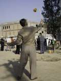 Man Spins a Top Along a String in the Market Square, Qinghai, China Photographie par David Evans