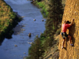 Man Climbing a Rock Wall above the River, Oregon Photographic Print by Kate Thompson